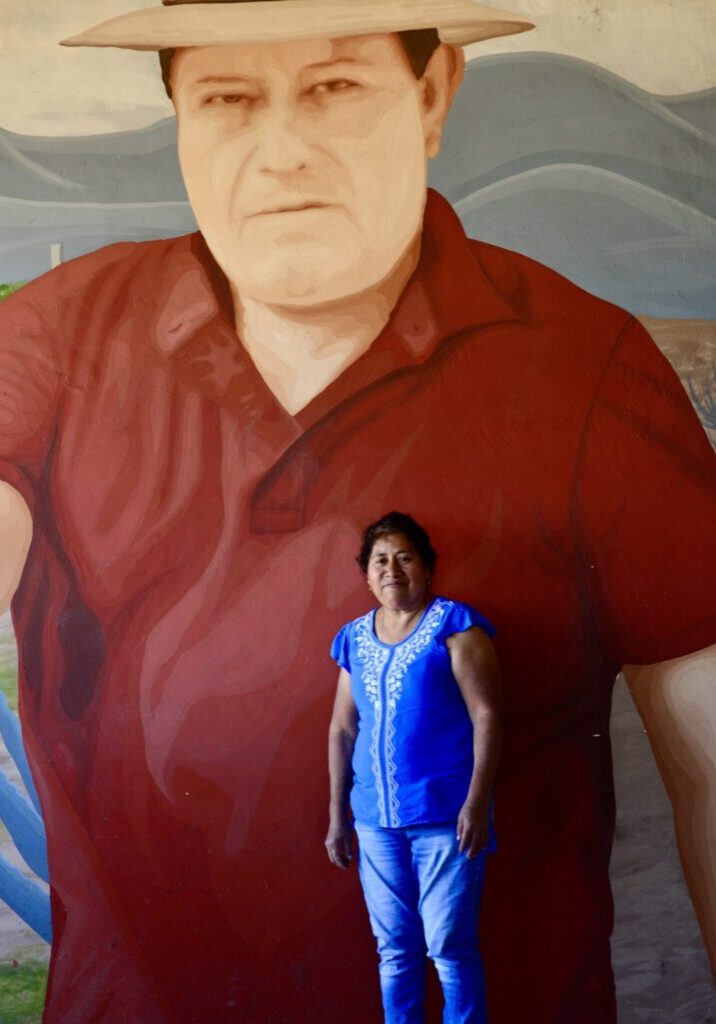 Hortensia stands before a mural of her late husband Juan. (Photo: Karen Otter)